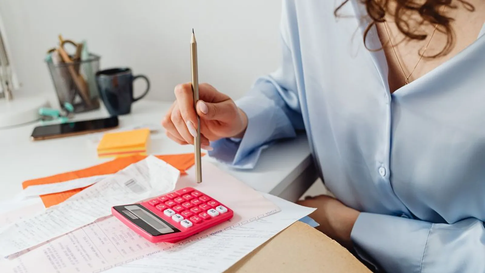 Working through bills and a calculator at a desk