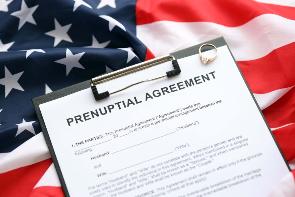 Prenuptial agreement and wedding ring on the table. Prenuptial paperwork process in the United States close up